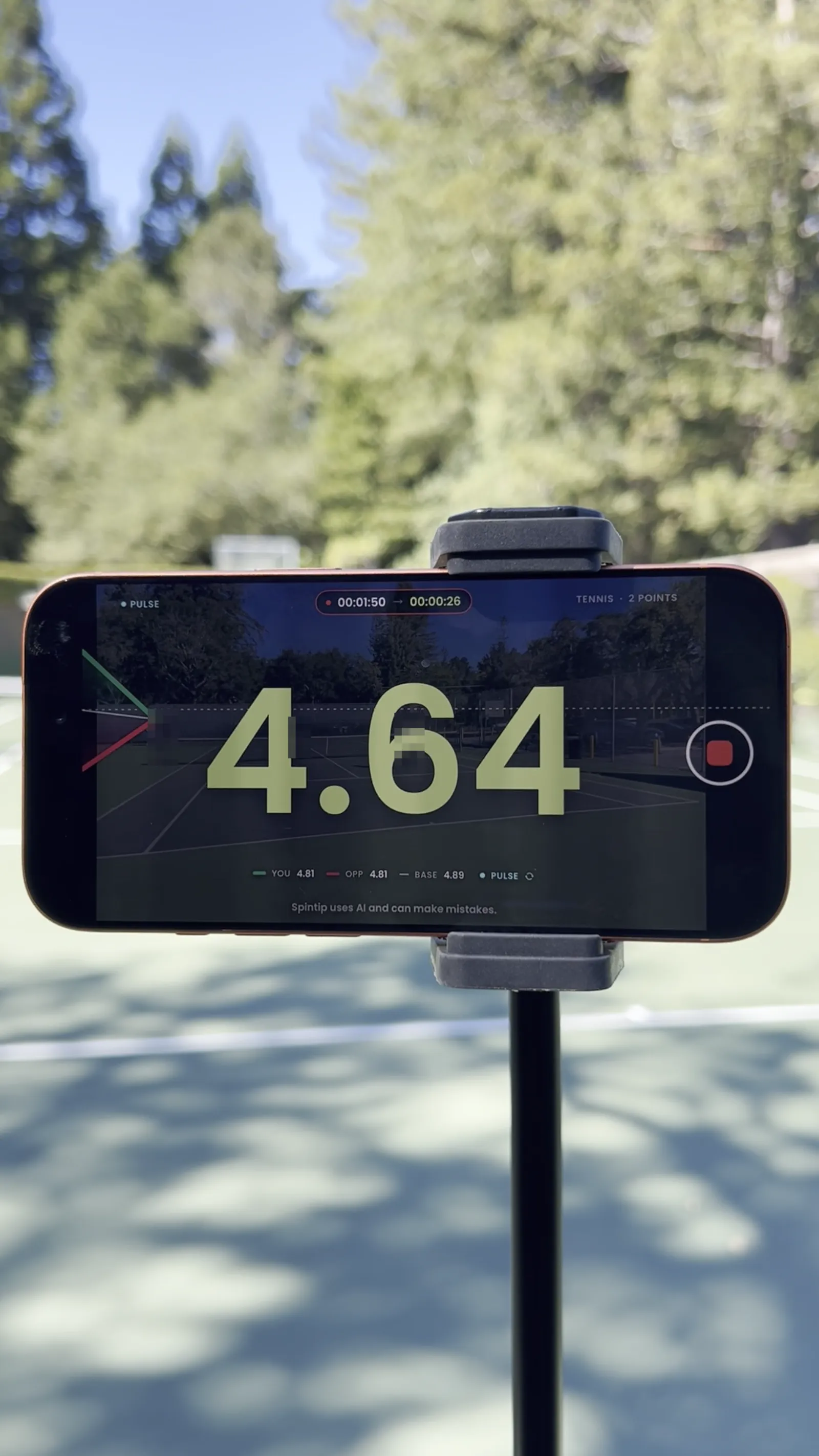 A phone on a stand behind the baseline